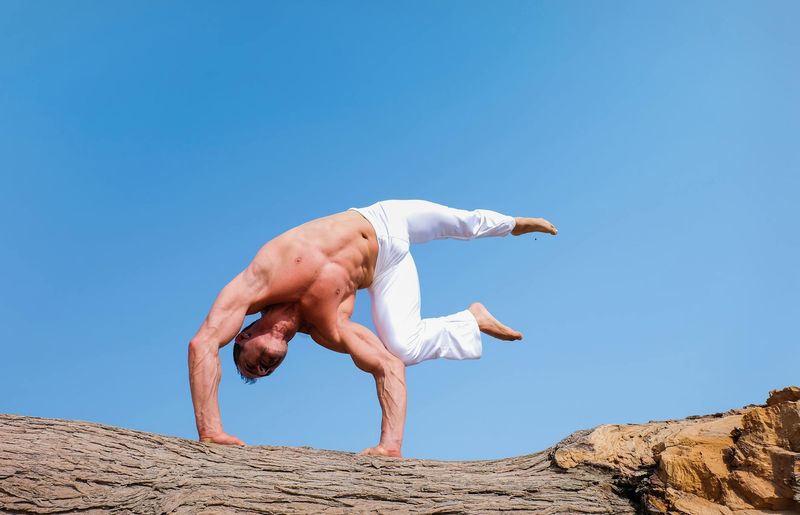 A man in motion, performing a dynamic bodyweight exercise.
