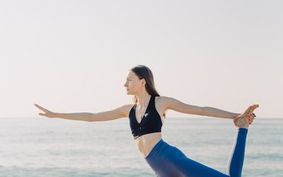 A person holding a challenging balance pose on one leg.