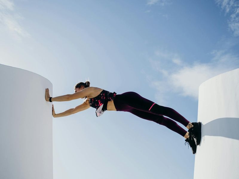 Man performing a controlled bodyweight exercise in a minimalist gym.