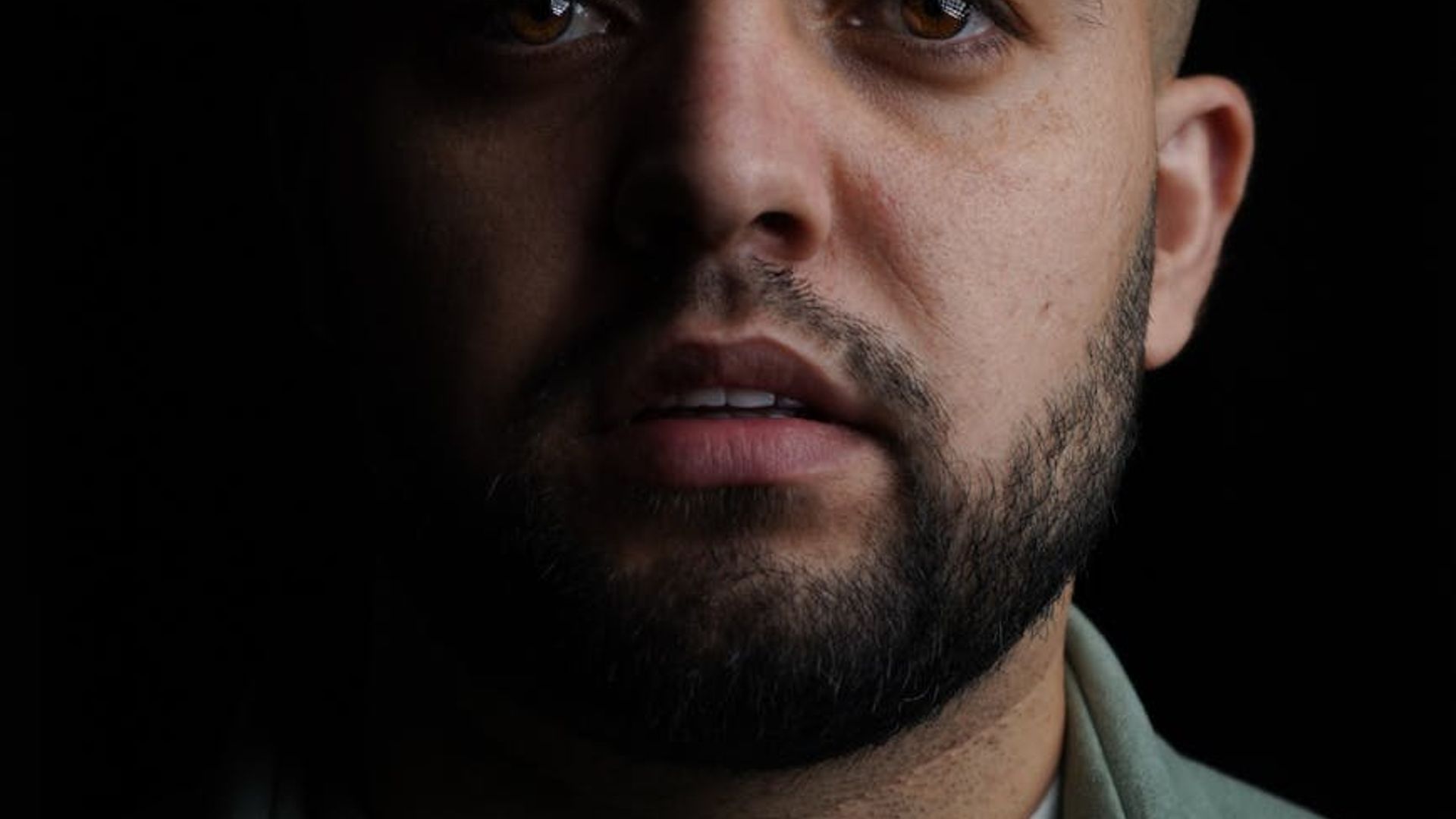 Silhouette of a man in a powerful stance against a dark, moody background.